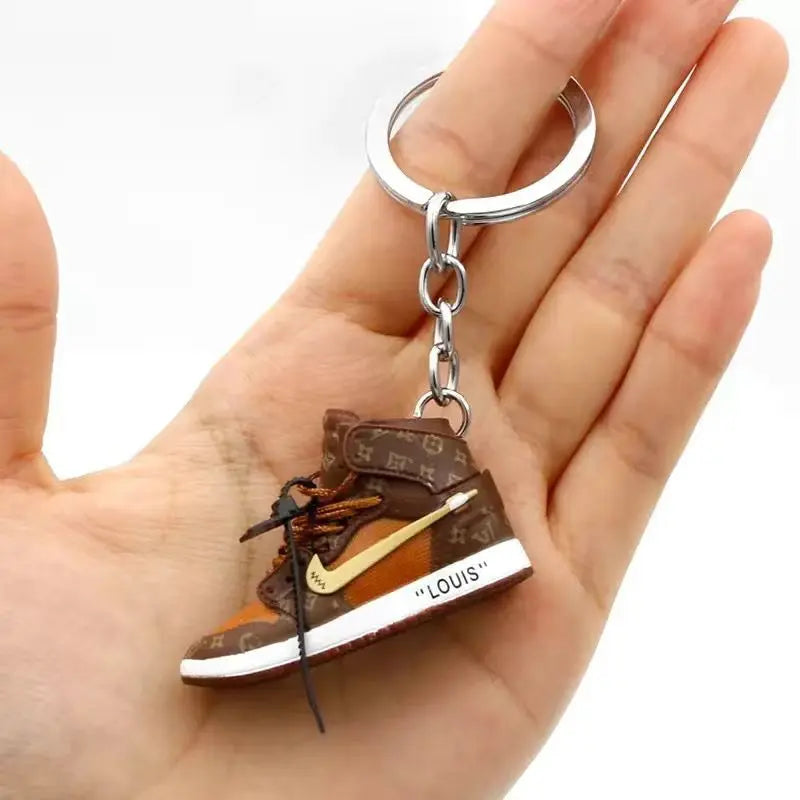 Miniature brown sneaker keychain held in an open palm