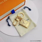 Monogram envelope keychain arranged on a cream drawstring pouch