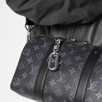 Dark loop keychain clipped to a monogram bag strap