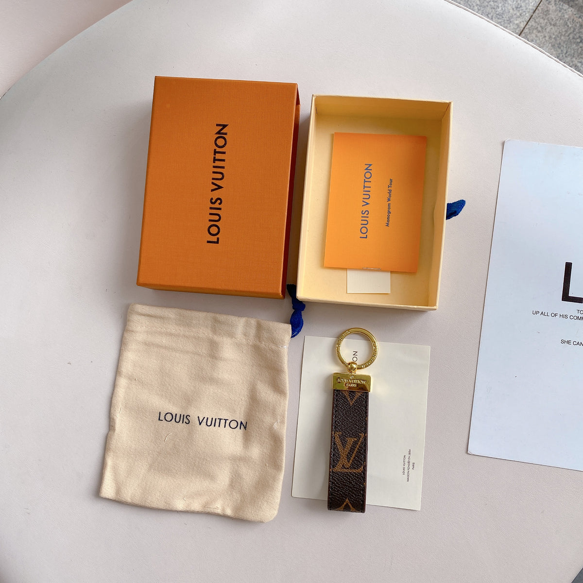 Brown monogram key holder displayed flat with its packaging