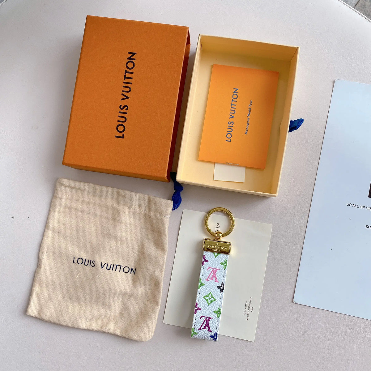 White multicolor monogram strap key holder with gold-tone ring