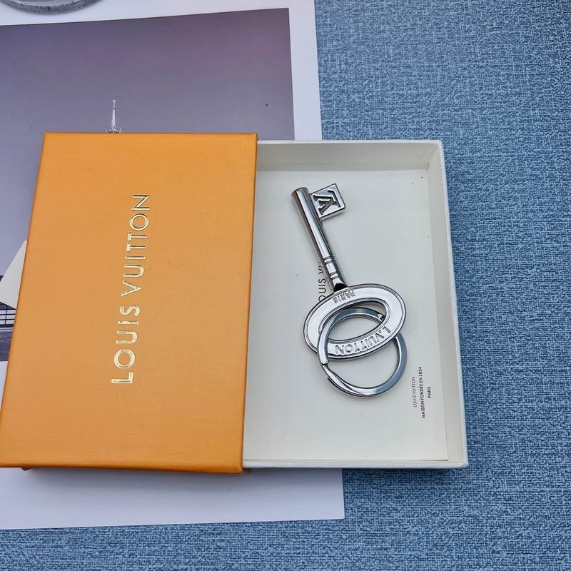 Key-shaped silver-tone keychain resting inside an orange box