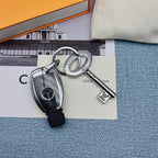 Key-shaped charm and black car key arranged on printed cards