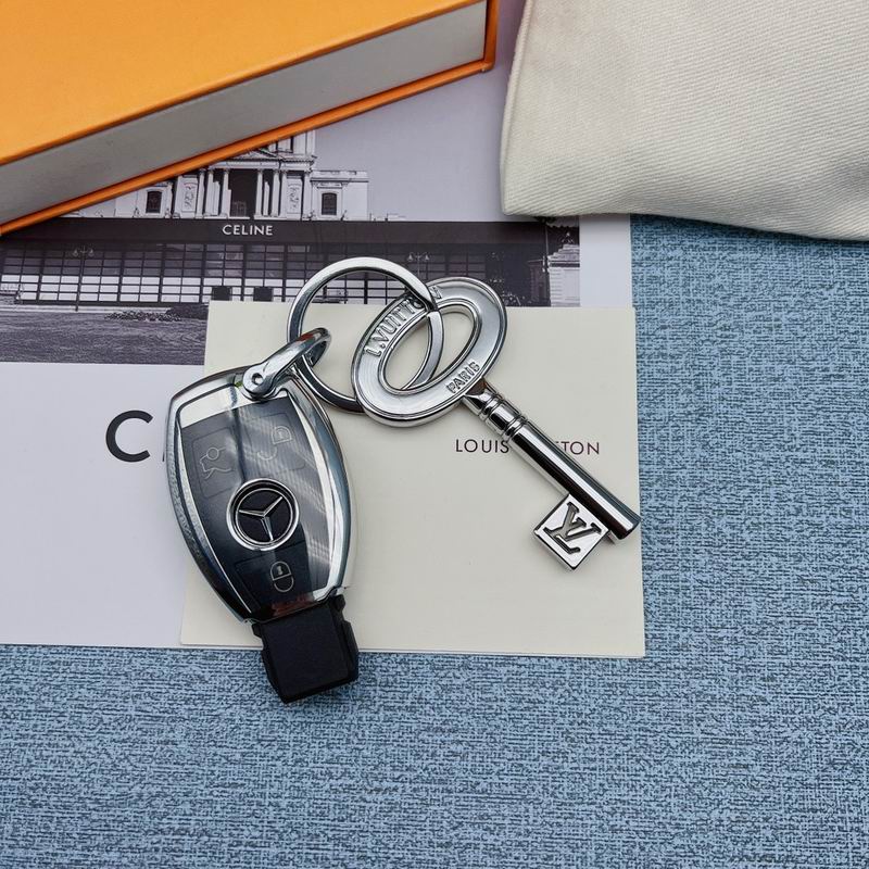 Key-shaped charm and black car key arranged on printed cards
