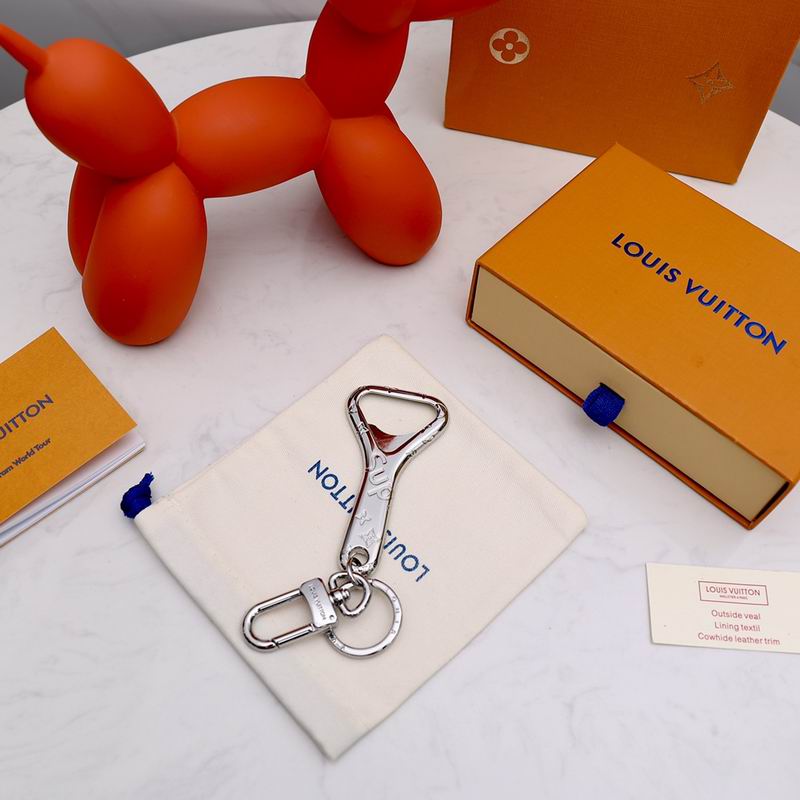 Bottle opener keychain arranged on a cream pouch beside packaging