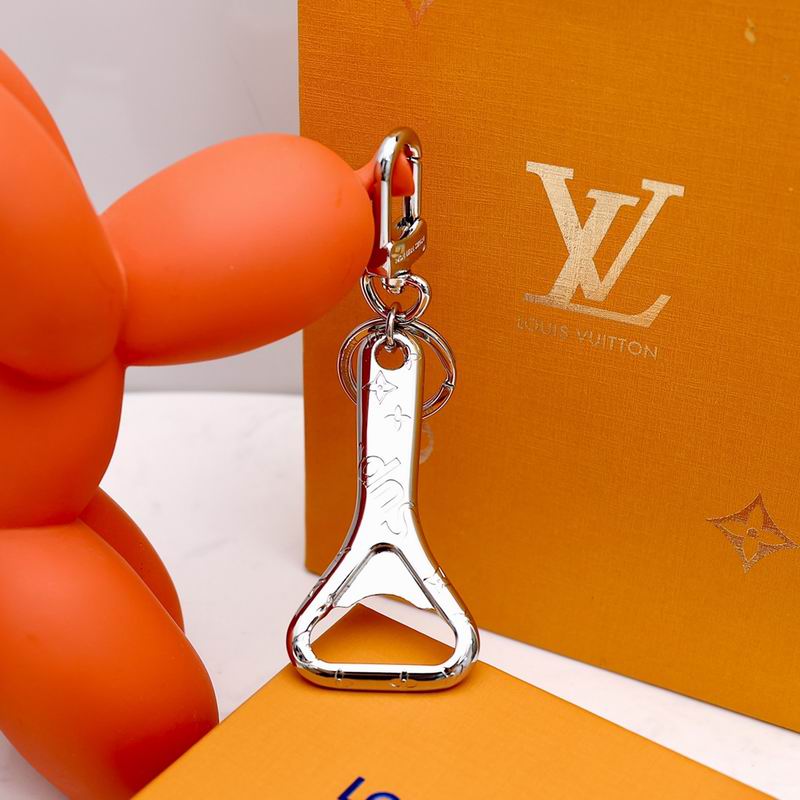 Silver-tone bottle opener keychain hanging vertically beside orange packaging