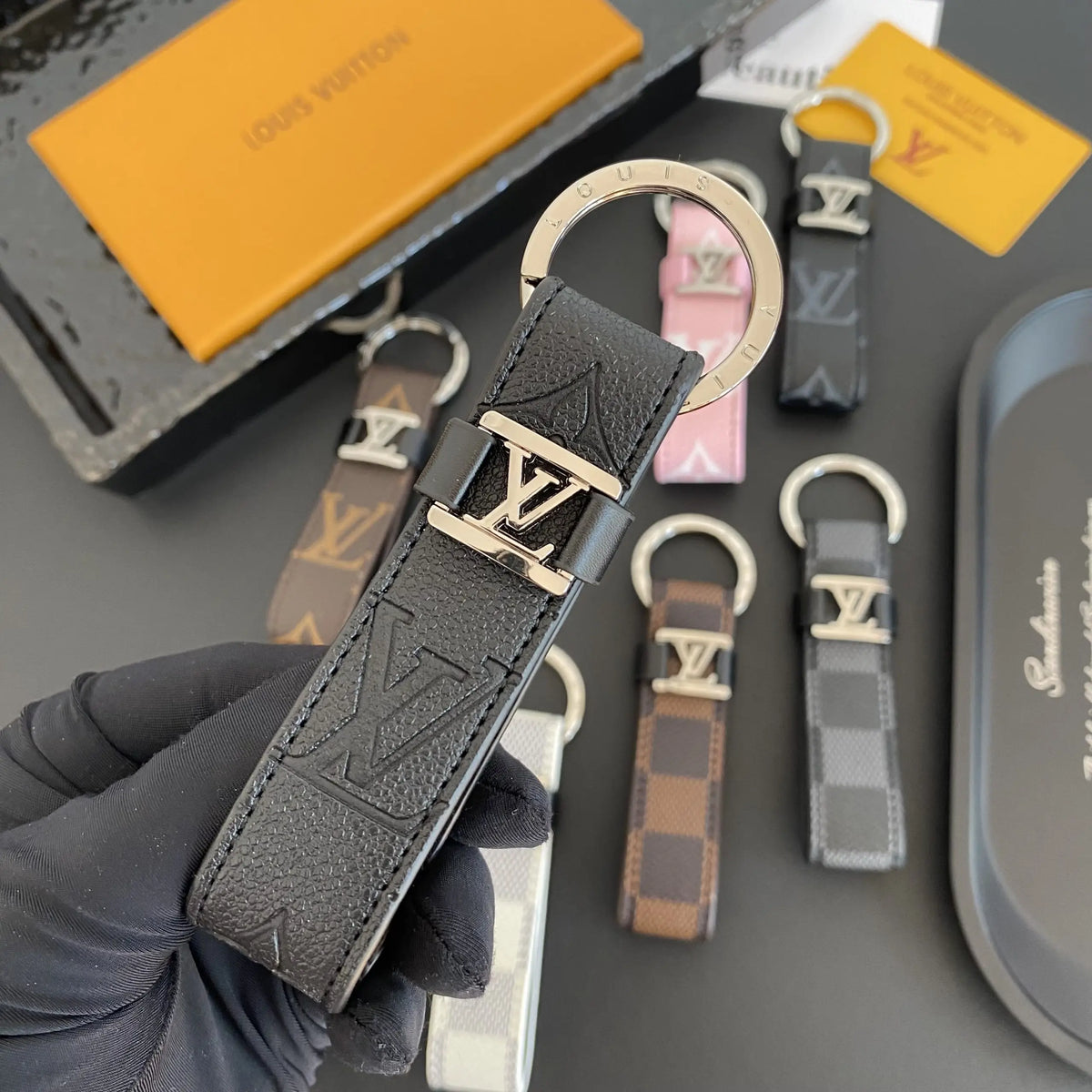 Black embossed monogram key holder shown close up