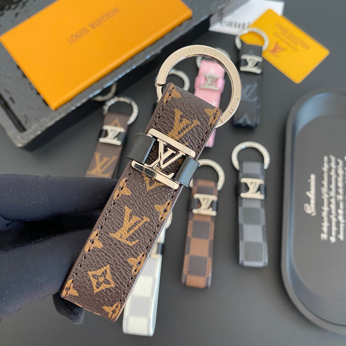 Brown loop key holder with small monogram pattern