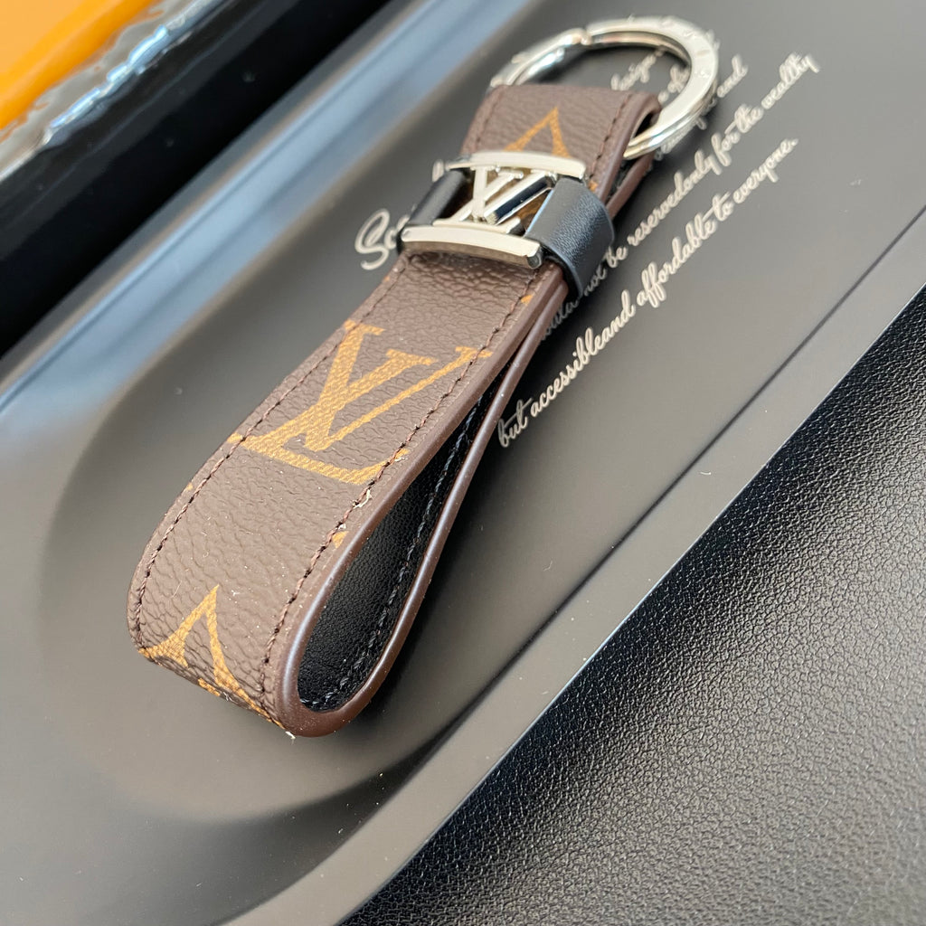 Angled view of brown monogram key holder and folded loop