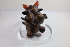 Angled view of brown cow keychain on a clear display