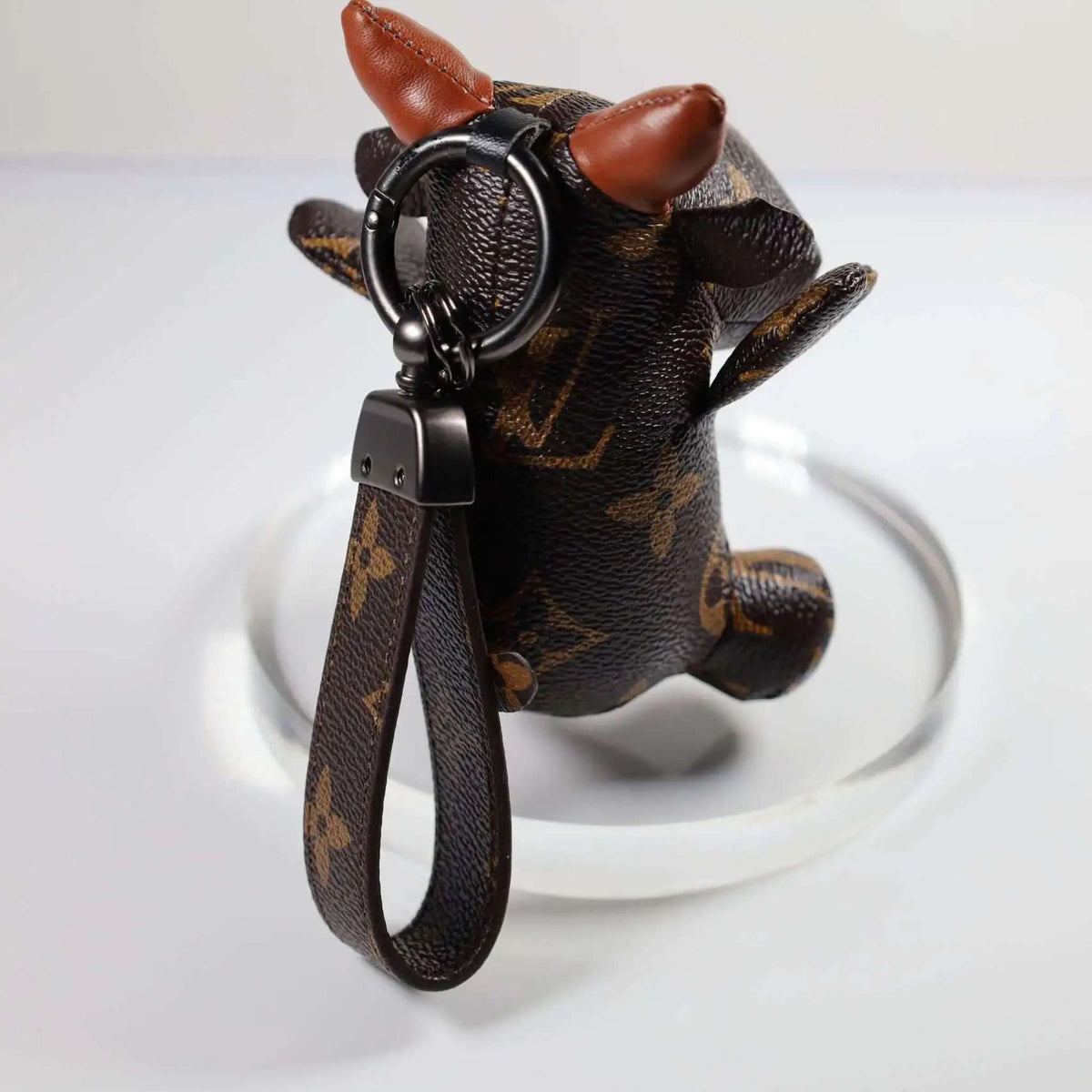 Rear view of cow keychain with brown monogram loop strap