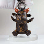 Front view of cow keychain held by its dark keyring