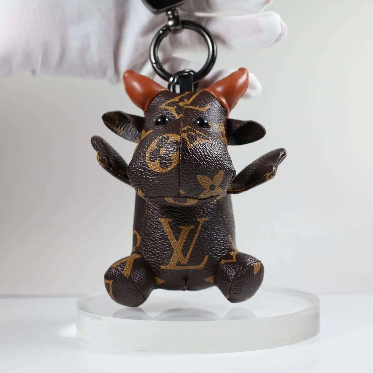 Front view of cow keychain held by its dark keyring