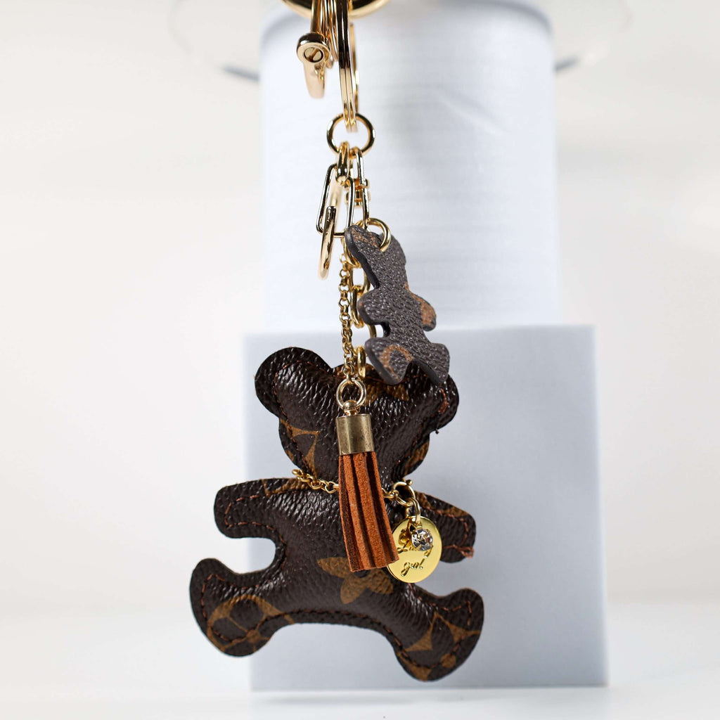 Side view of bear keychain with tan tassel and small pendant