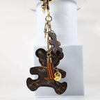 Side view of bear keychain with tan tassel and small pendant