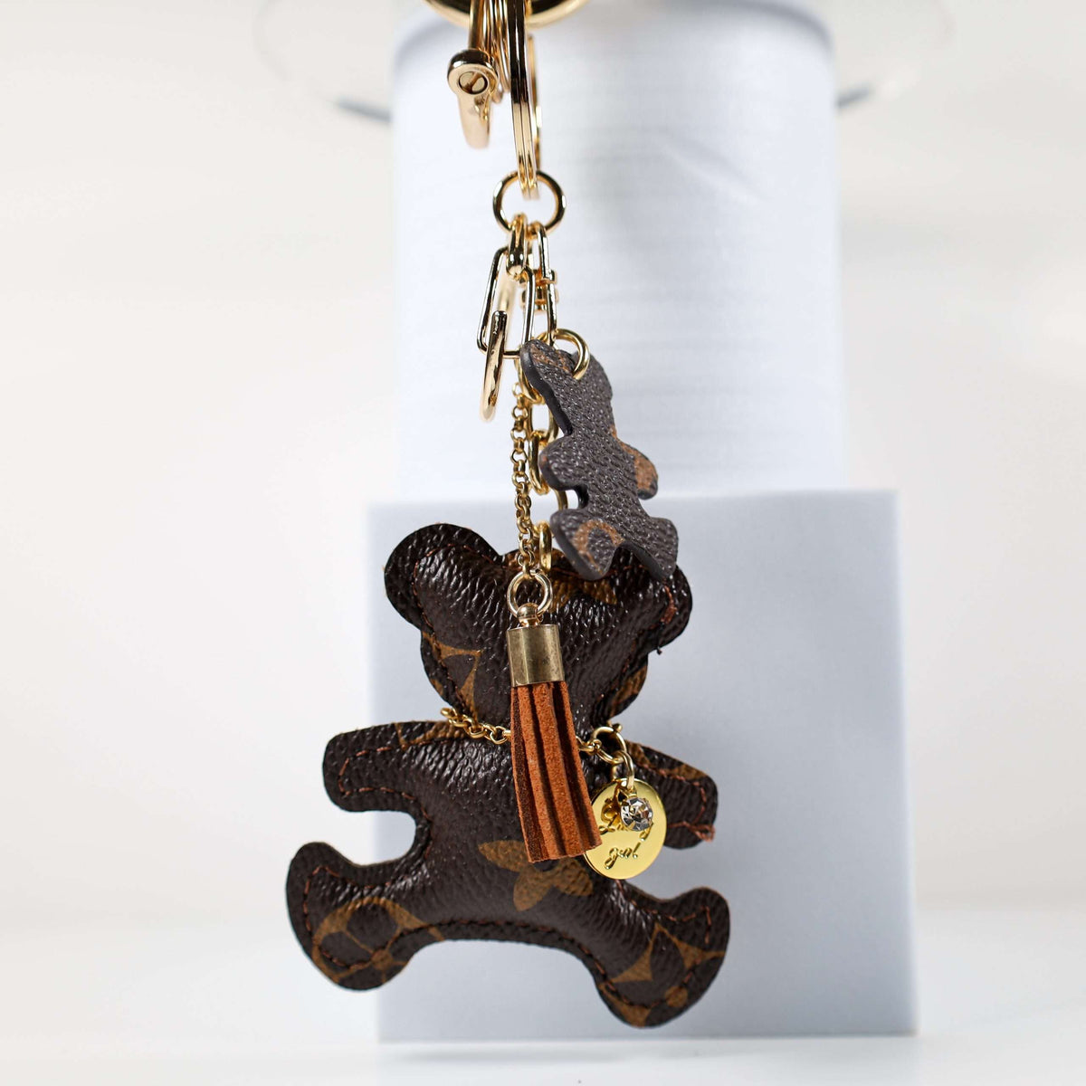 Side view of bear keychain with tan tassel and small pendant