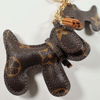 Close-up of brown monogram dog charm and tan tassel