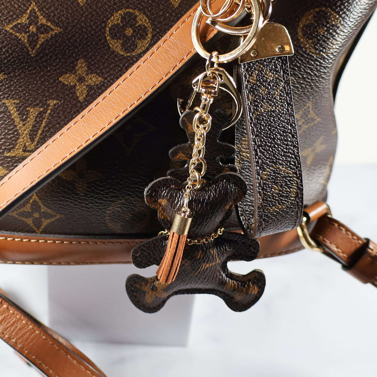 Bear keychain and tassel attached to a monogram bag