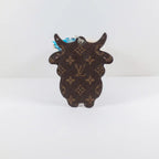 Reverse of brown monogram cow keychain showing its horn silhouette