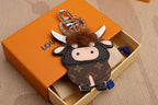 Brown monogram cow keychain with white horns and fluffy fringe