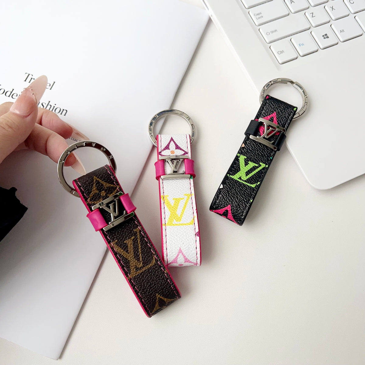 Brown pink-trimmed key holder held beside white and black styles