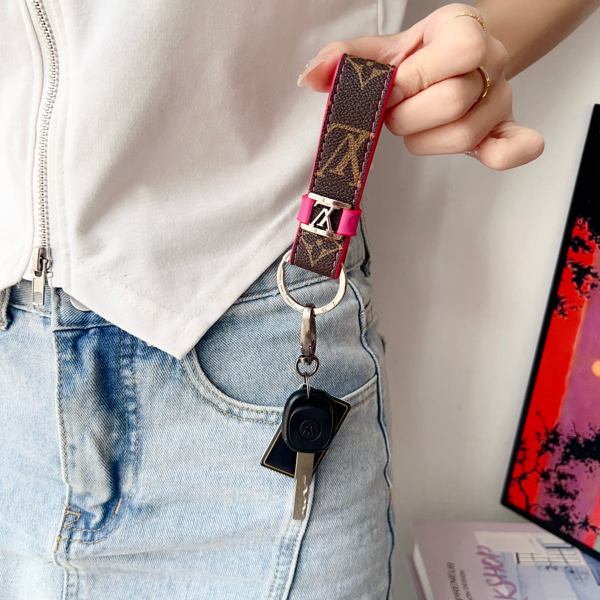 Brown monogram loop key holder shown attached to keys