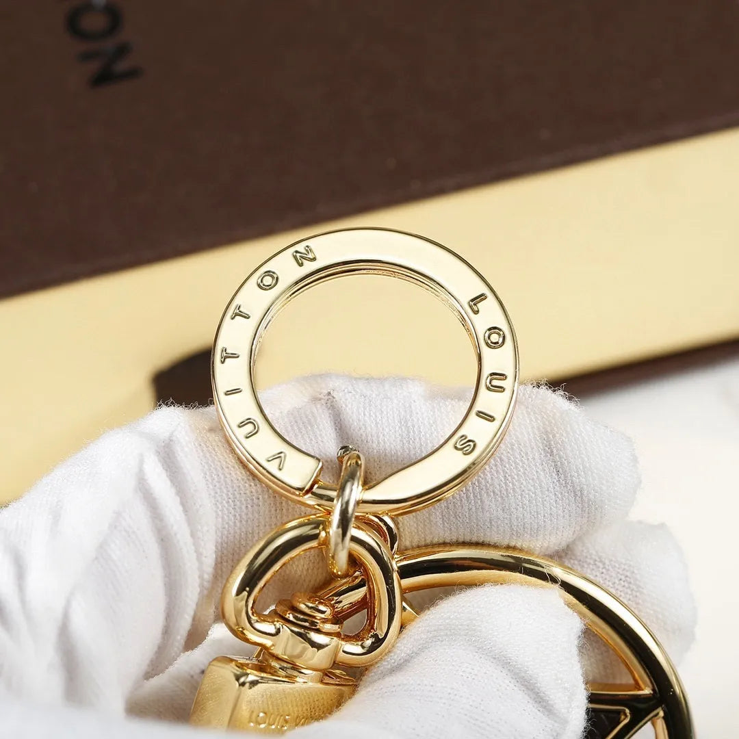 Close-up of engraved round ring on gold-tone flower keychain