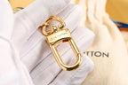 Gold-tone keychain clasp and connecting loop shown close up