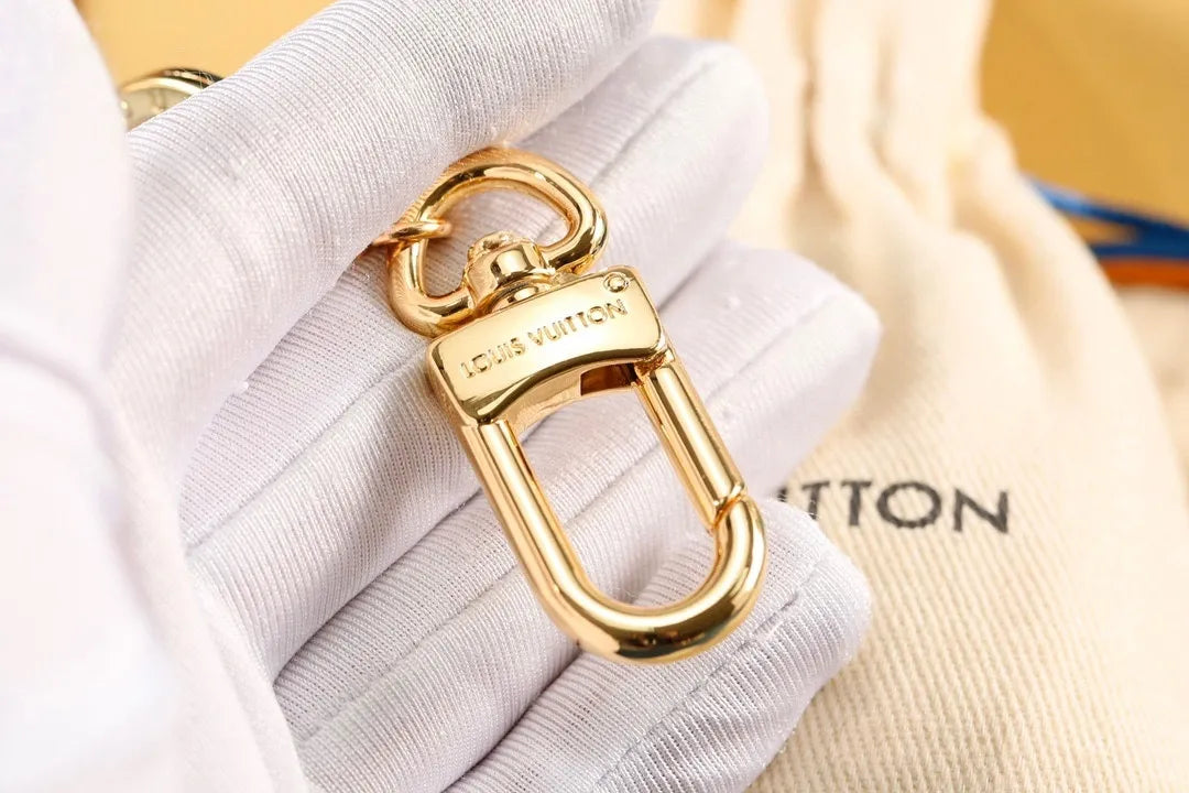 Gold-tone keychain clasp and connecting loop shown close up