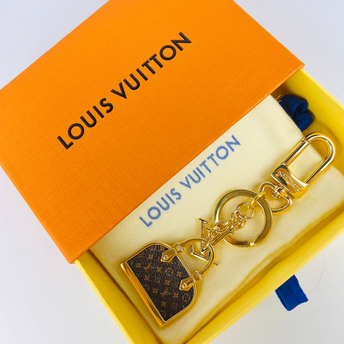 Brown monogram handbag charm keychain in an orange box