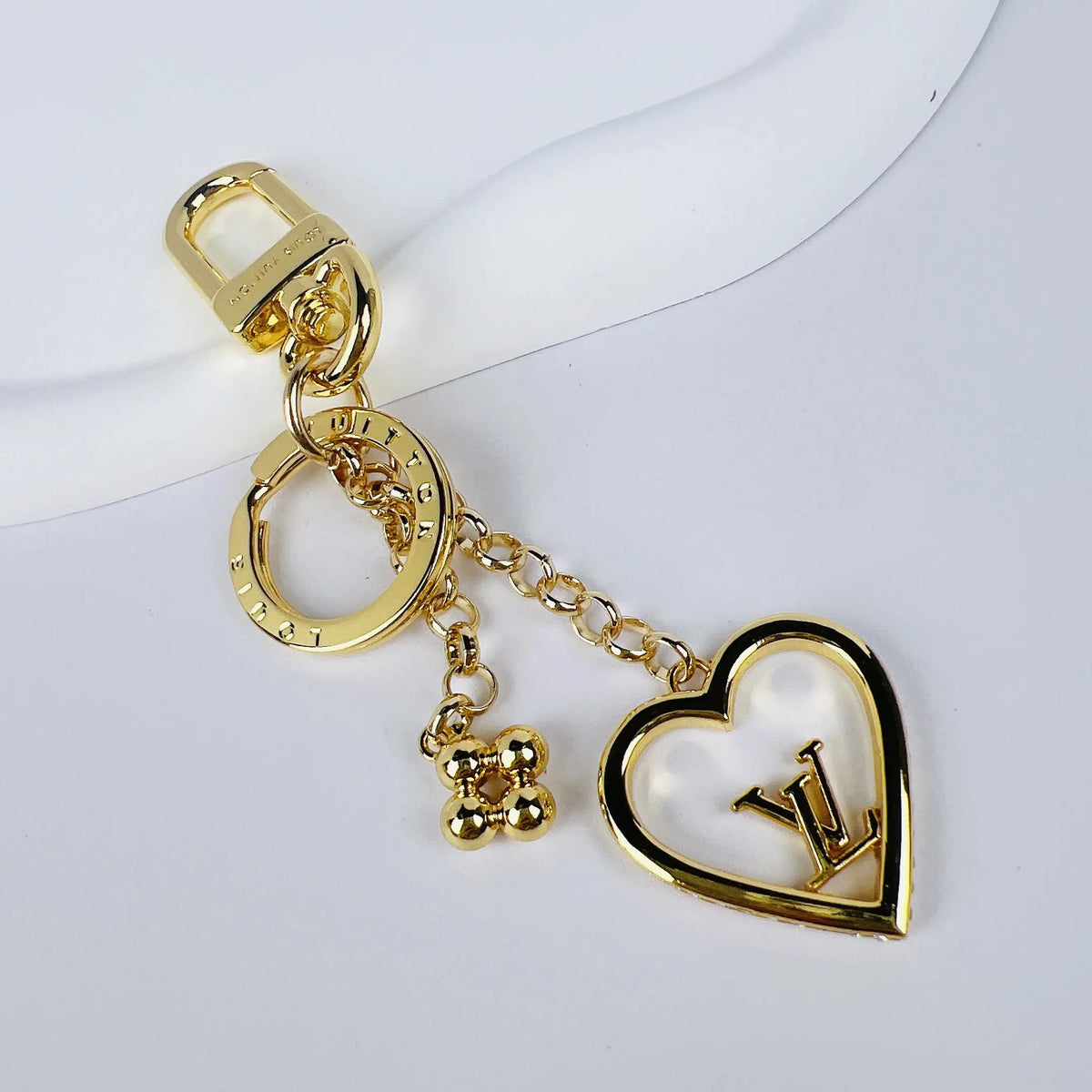 Pearlescent heart keychain with small gold-tone floral charm