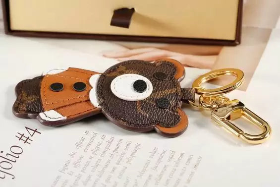 Brown bear keychain laid flat beside its gold-tone clasp