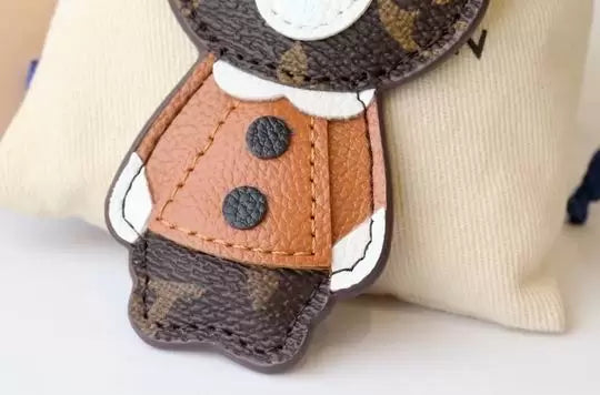 Bear charm showing stitched tan jacket and black buttons