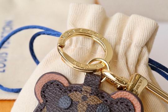 Close-up of bear keychain ears and engraved gold-tone keyring