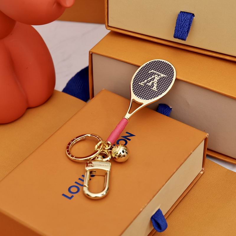 Gold-tone tennis racket keychain with pink grip and ball charm