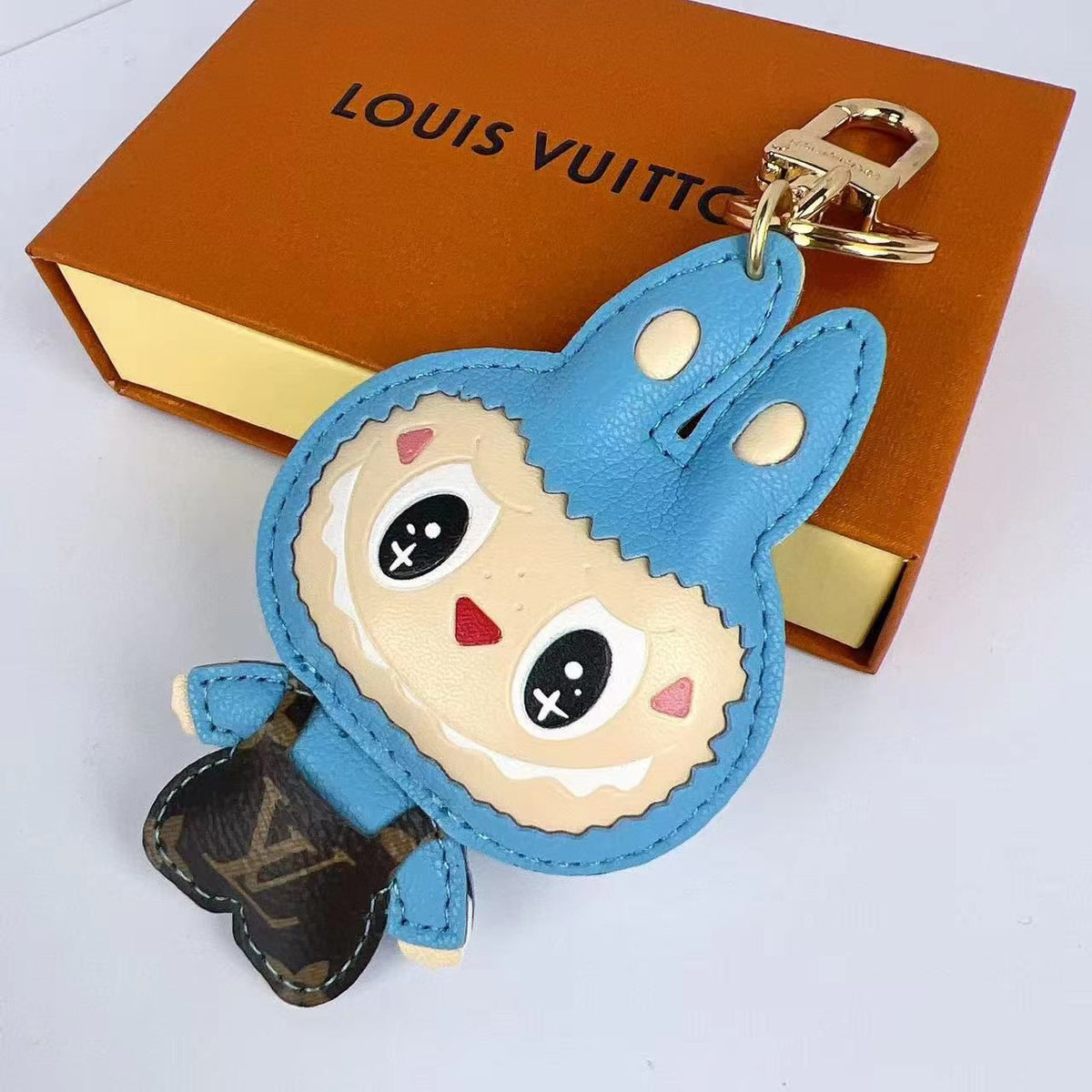 Blue Labubu keychain with dark monogram body and pointed ears
