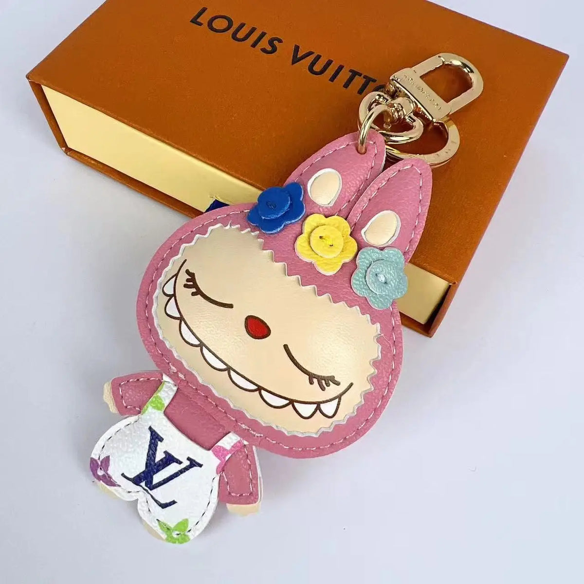 Pink Labubu keychain with closed eyes and flower details