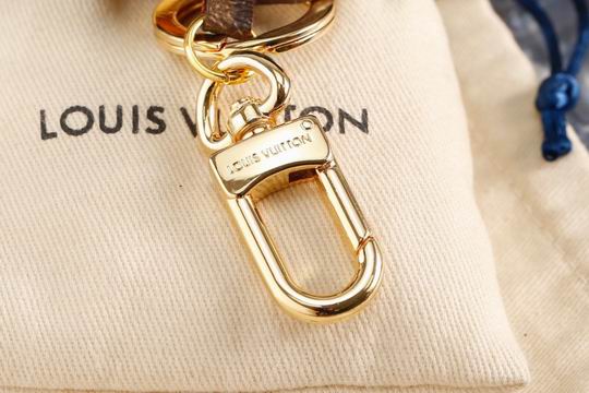 Gold-tone swivel clasp of lion keychain shown on fabric