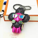 Metallic pink Vivienne keychain with dark petals and iridescent sunglasses
