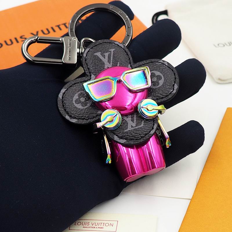 Pink Vivienne charm with rainbow sunglasses held in a dark glove
