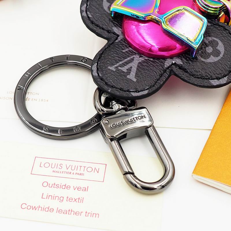 Close-up of Vivienne sunglasses, headphones, and dark keyring