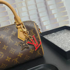Red LV and flower keychain attached to a monogram bag