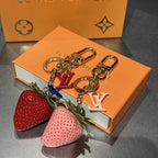 Red and pink strawberry keychains with gold-tone hardware