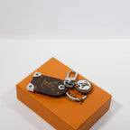 Brown monogram tag keychain with silver-tone corner details