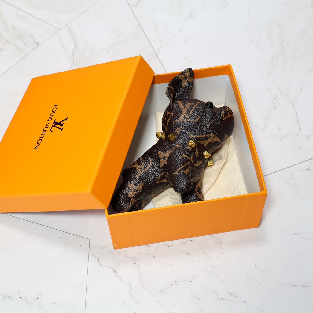 Brown monogram bulldog keychain resting inside an orange box