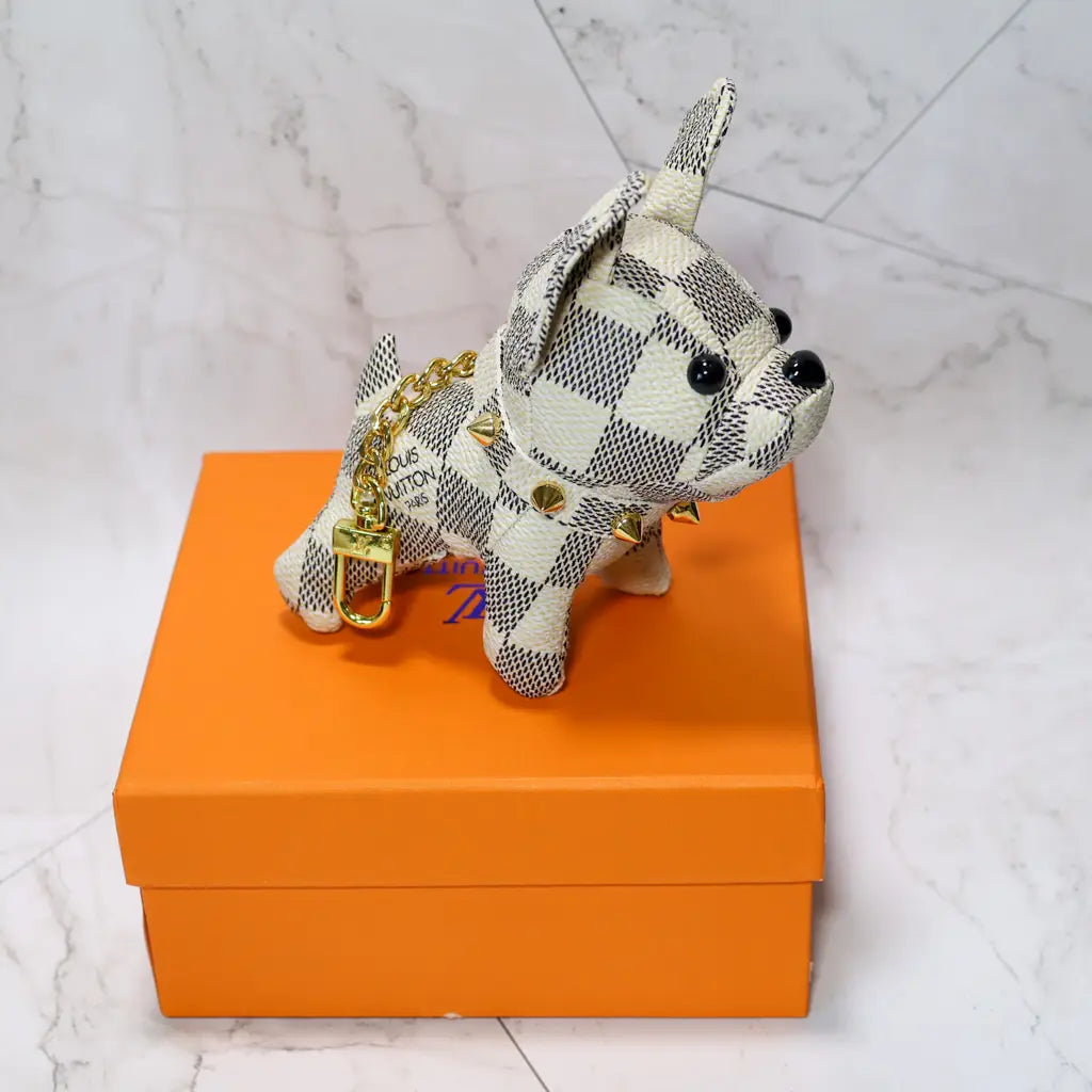 White checkered bulldog keychain standing on an orange box