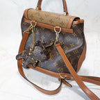 Brown monogram bulldog charm hanging from a matching backpack
