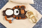 Cat keychain lying sideways on a cream fabric pouch