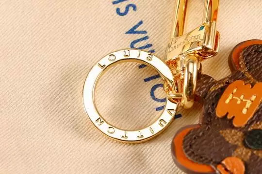 Close-up of engraved gold-tone ring on cat keychain