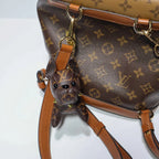 Monogram dog charm attached to a matching brown backpack